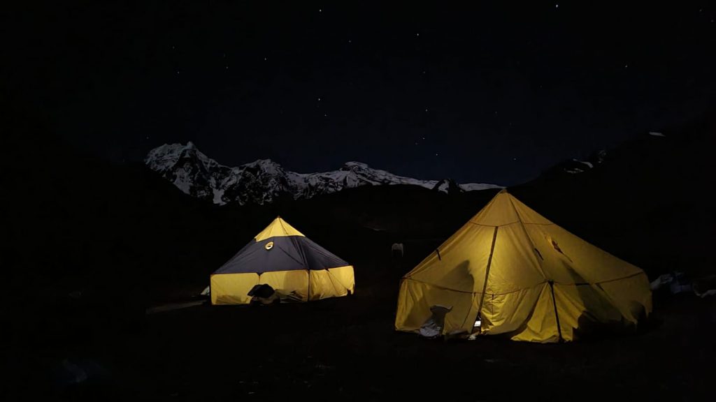 Camping by Ausangate Lagoon with reflection of snow-capped peaks