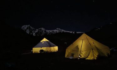 Camping by Ausangate Lagoon with reflection of snow-capped peaks