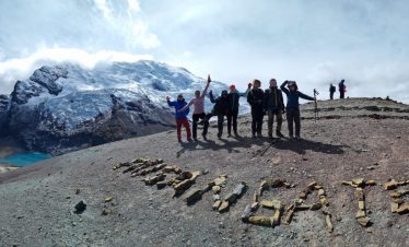 Group hiking through Warmisaya Pass with scenic mountain backdrop