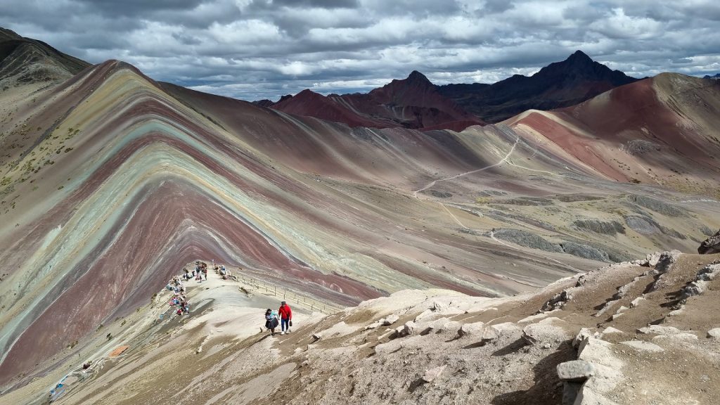 Traveler reaching the summit of Rainbow Mountain Vinicunca on the Ausangate and Red Valley 2 Day Trek from Cusco