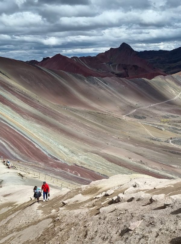 Traveler reaching the summit of Rainbow Mountain Vinicunca on the Ausangate and Red Valley 2 Day Trek from Cusco