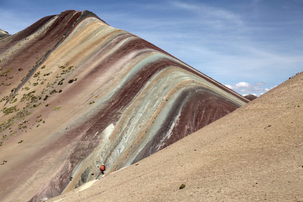 Rainbow Mountain in Cusco, Peru showing its real natural colors with soft earthy tones under morning sunlight
